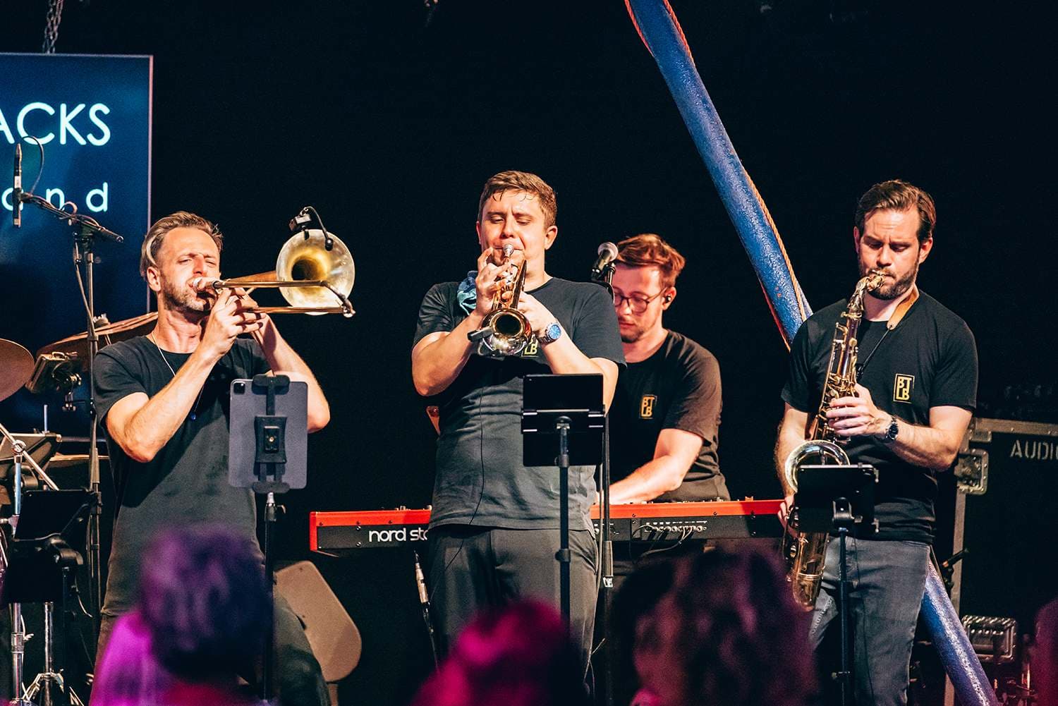 The horn section of Brass Tacks Live Band on stage