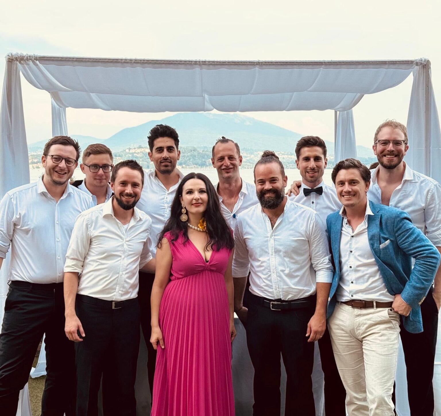 Die gesamte Brass Tacks Band steht entspannt am Ufer des Lago Maggiore in Italien, schaut freundlich in die Kamera, mit einer ruhigen und professionellen Ausstrahlung.